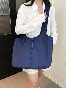 Foldable navy nylon tote bag with drawstring detail and large capacity for daily use