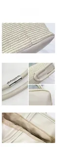Close-up of woven straw handbag showing cream leather handle and silver metal buckle