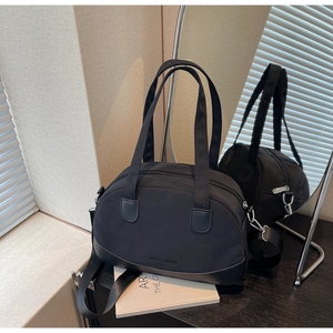 Detail of black mini Boston shell bag with dual handles and detachable shoulder strap