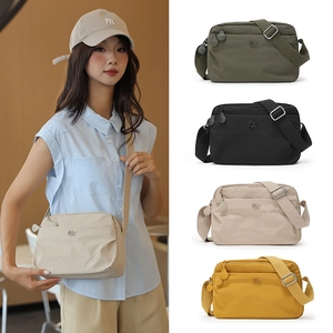 Detail showing various colors of nylon shoulder bags with adjustable wide fabric straps