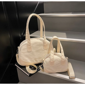Close-up of cream white shell tote bag set with textured fabric and embossed logo
