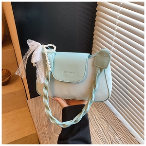Detail of mint green shoulder bag with pearl chain and delicate lace bow accent