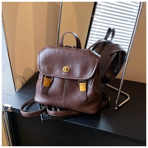 Detailed view of dark brown vintage faux leather backpack with gold rotary clasp and hardware
