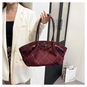 Detailed close-up of wine red suede tote bag with white diamond quilted stitching pattern