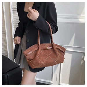 Detail of caramel suede tote bag with white diamond stitching and sleek wing structure