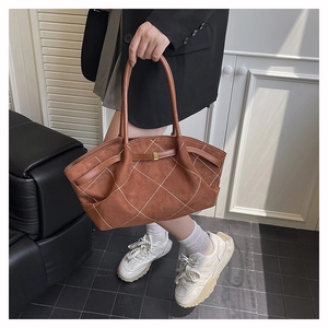 Macro shot of brown suede tote bag featuring white diamond quilted stitching details