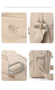 Detail view of nylon crossbody bag featuring embossed logo, zipper pull, and metal buckle
