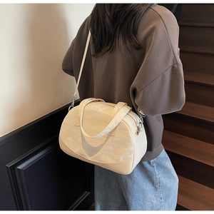 Detailed view of a creamy white mini shell bag with leather trim and texture details