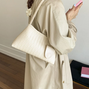 Borsa hobo beige intrecciata alla moda con pochette abbinata indossata da una modella