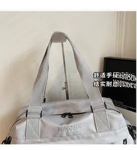 Dettaglio della borsa da viaggio grigio chiaro che mostra la trama in nylon e le doppie cerniere