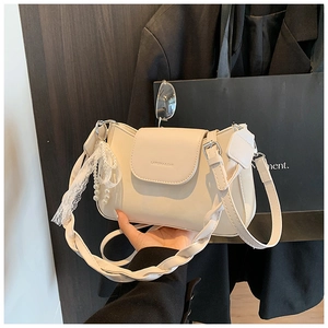 Detail of cream white PU leather shoulder bag with wide braided strap and pearl lace charm