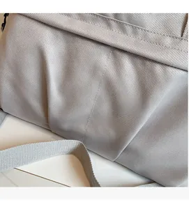 Dettaglio del tessuto in saia grigia della borsa da viaggio con tracolla intrecciata