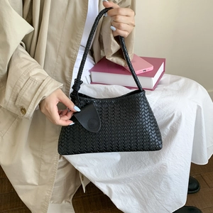 Dettaglio della trama in pelle intrecciata nera e del nodo sulla borsa a tracolla