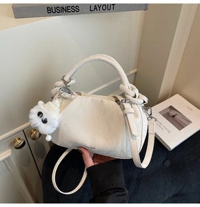 Close-up of off-white pleated dumpling bag texture with cute monster plush charm