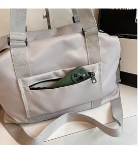 Dettaglio della borsa da viaggio in nylon grigio con tasca frontale con zip e tracolla