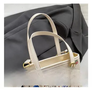Détails des poignées en cuir et des attaches métalliques dorées sur le sac graffiti
