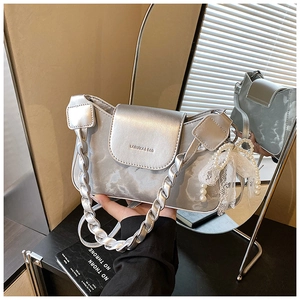 Detail of silver handbag with marble texture, lace bow charm, and pearl strap decoration