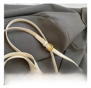 Detail der verstellbaren Schultergurte und goldfarbenen Beschläge der weißen Ledertasche