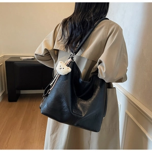 Detail of black large Hobo tote bag with soft leather texture and bear charm