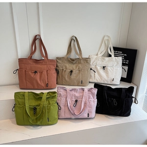 Detail showing colorful large capacity drawstring tote bags in six different colors