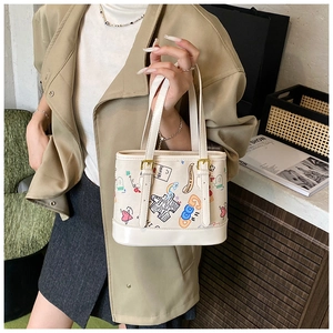 Détail du sac cabas crème avec motifs graffiti colorés et double poignée élégante