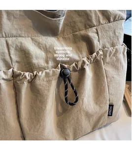 Detail of khaki nylon tote bag featuring a practical drawstring closure and fabric texture