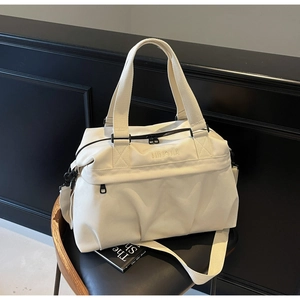 Dettaglio della borsa da viaggio bianco crema con ricamo NINGJIA e cerniere in metallo nero