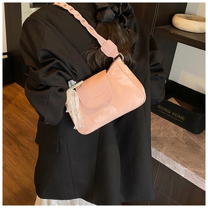 Detail of light pink shoulder bag with braided strap and pearl lace bow charm