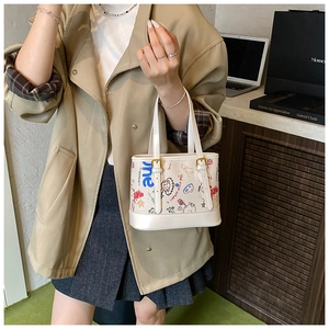 Détail du mini sac cabas blanc avec graffitis colorés et poignées réglables sur modèle
