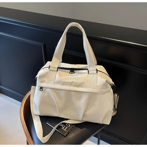 Dettaglio della borsa da viaggio bianco crema con ricamo del brand e cerniere resistenti