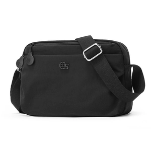 Close-up of black nylon crossbody bag with multiple zippers and round metal logo detail