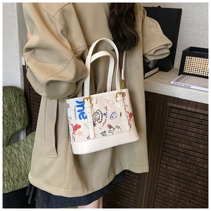 Détail du sac en cuir blanc avec graffiti de dessin animé et boucles métalliques dorées