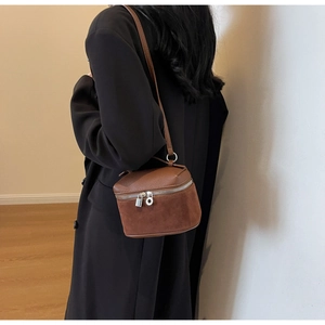 Side view of dark brown frosted suede vanity crossbody bag with silver hardware on model
