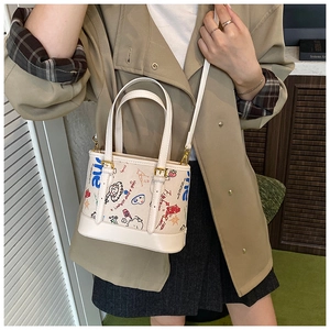 Détail du sac cabas beige avec imprimés graffiti colorés et boucles dorées