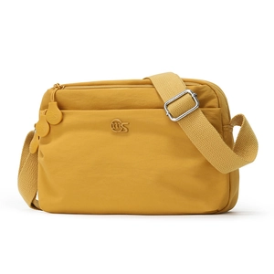 Detail of bright yellow nylon crossbody bag featuring MS logo and adjustable strap