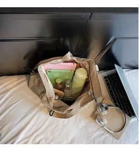 Spacious interior of beige tote bag showing compartments for laptop and water bottle