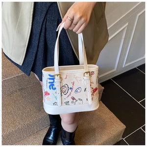 Détail du sac à main blanc graffiti avec art de dessin animé et ferrures dorées