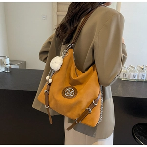 Dettaglio della borsa tote vintage in pelle scamosciata arancione con logo M e ciondolo