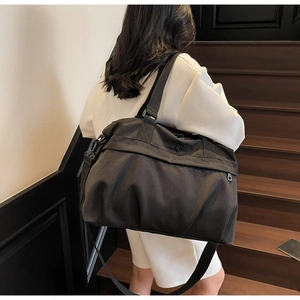 Vista posteriore dettagliata di una borsa da viaggio nera con tracolla in ambiente elegante