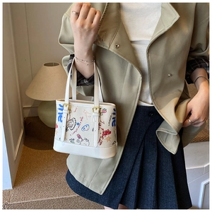 Détail du sac cabas blanc à graffitis avec imprimés colorés et boucle en métal doré