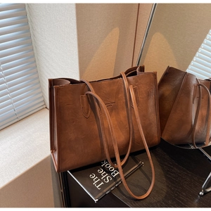 Detail of a brown tote bag featuring retro matte texture and fashion trend embossing