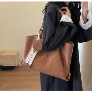 Brown quilted tote bag with diamond stitching and circular coin purse detail