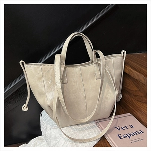 Close-up of cream tote bag featuring natural wrinkled texture and side drawstring detail