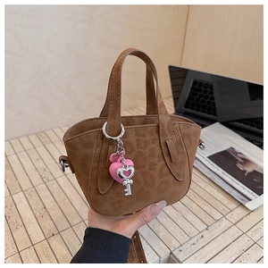 Close-up of leopard print handbag with heart charm on a minimalist desk setup