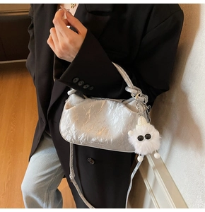 Silver metallic dumpling bag with Chic-2ab logo and white plush monster charm details