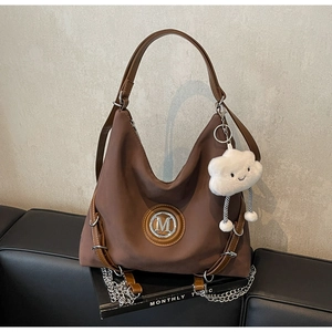 Dettaglio di una borsa Hobo marrone scuro con logo M in metallo e ciondolo a nuvola soffice