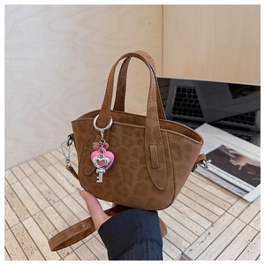 Detailed close-up of brown leopard print mini bag with silver heart and key charms