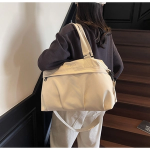 Dettaglio della grande borsa da viaggio in tela beige con ricamo NINGJIA e tasca con zip