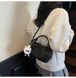 Chic black cloud-shaped crossbody bag with soft pleated texture and plush monster charm