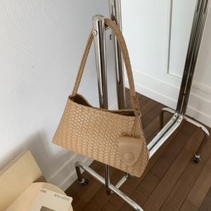 Dettaglio della trama a maglia della borsa a secchiello kaki con ciondolo portamonete